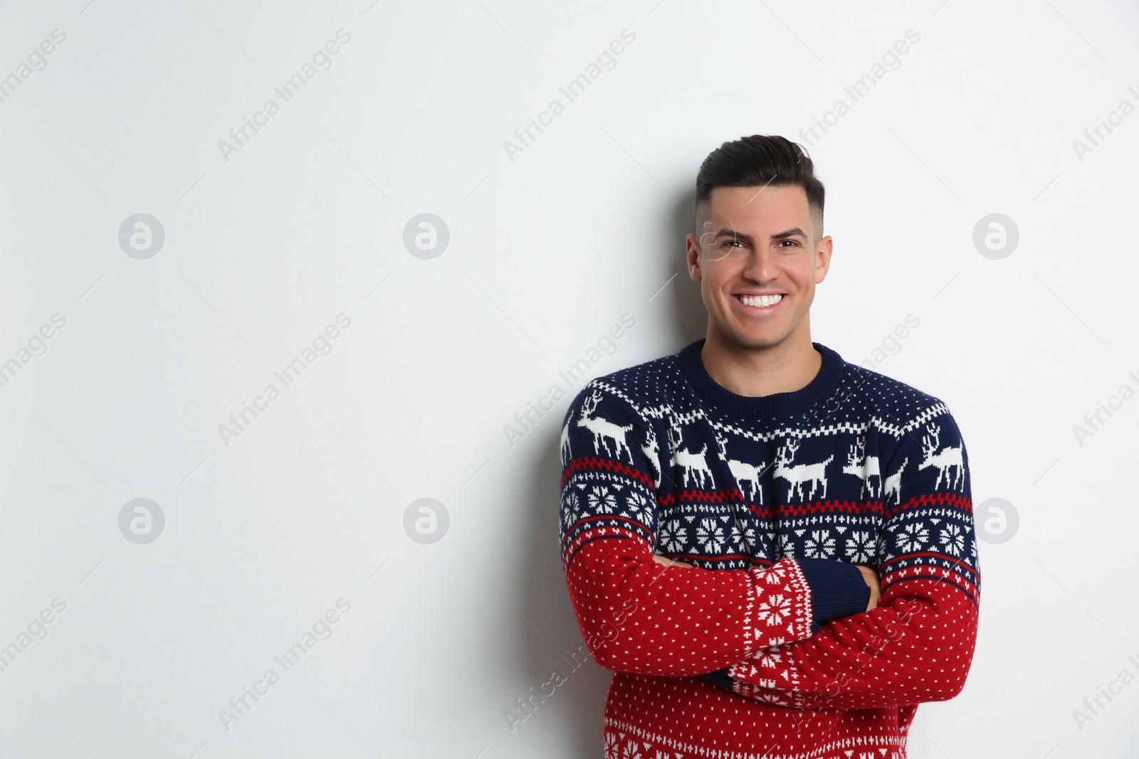 Photo of Handsome man in Christmas sweater on white background, space for text