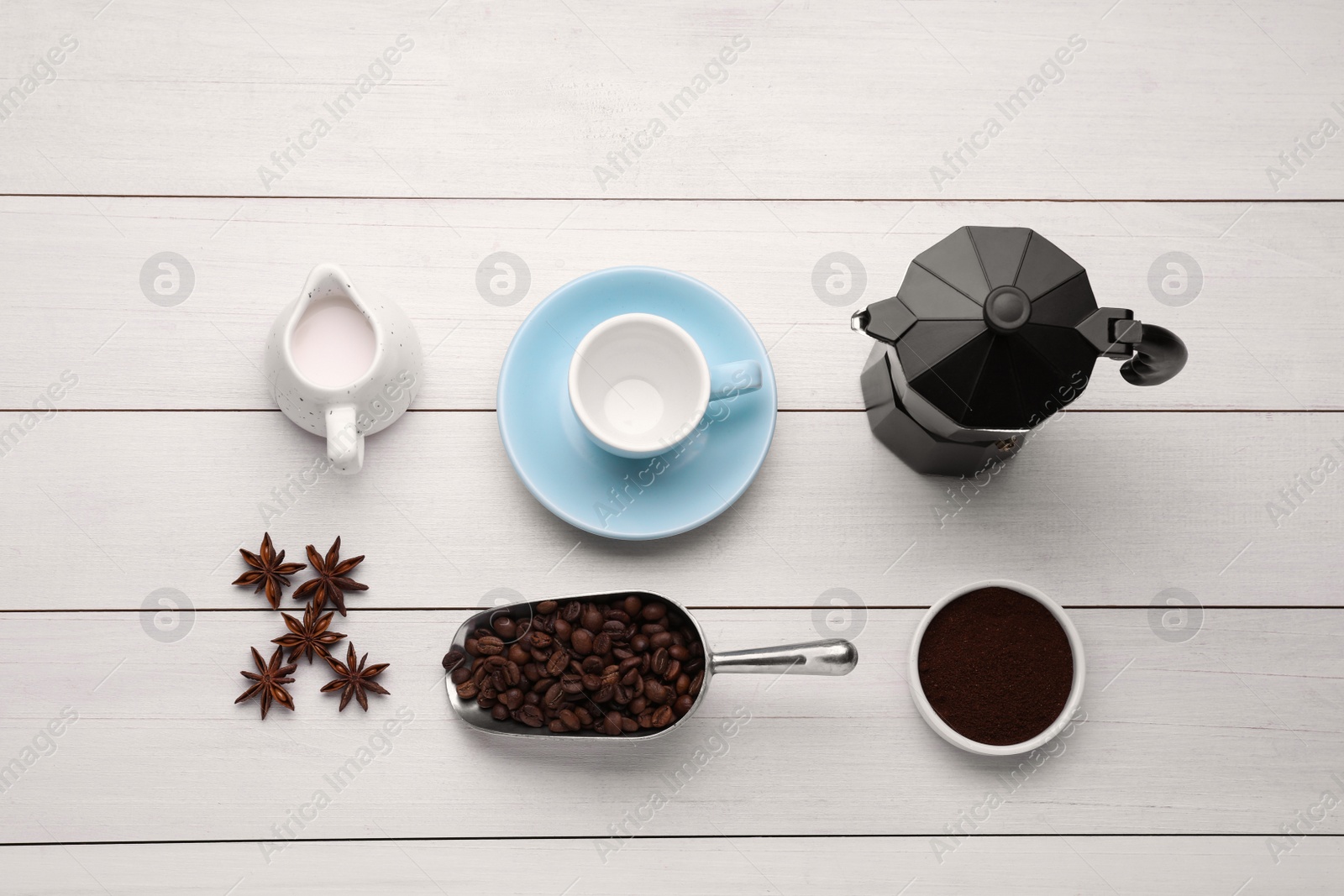 Photo of Flat lay composition with geyser coffee maker and roasted beans on white wooden background