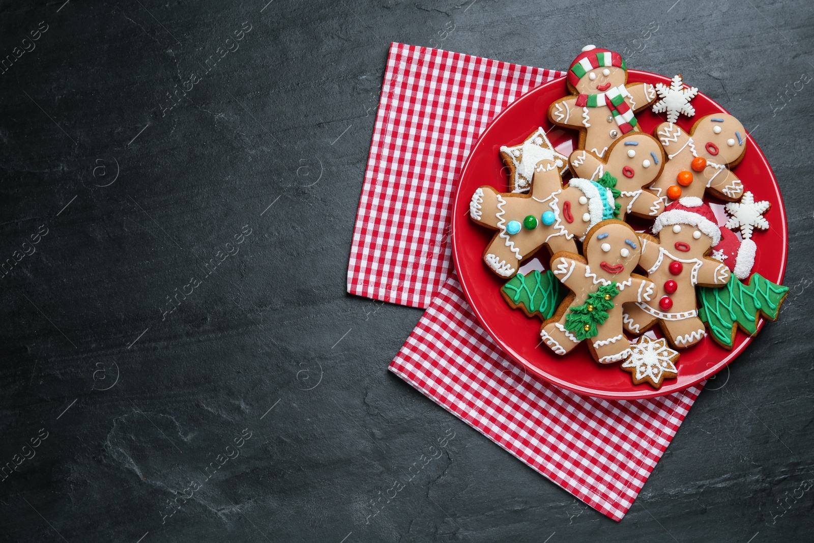 Photo of Delicious Christmas cookies on black table, top view. Space for text