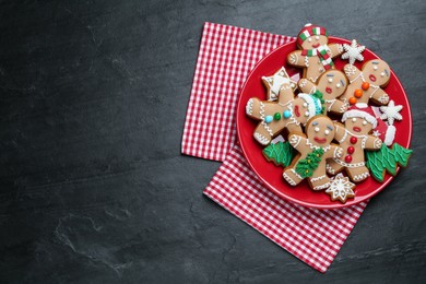 Photo of Delicious Christmas cookies on black table, top view. Space for text