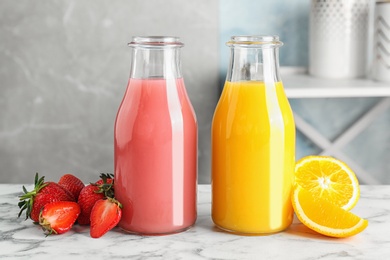 Photo of Bottles with tasty juices and ingredients on table