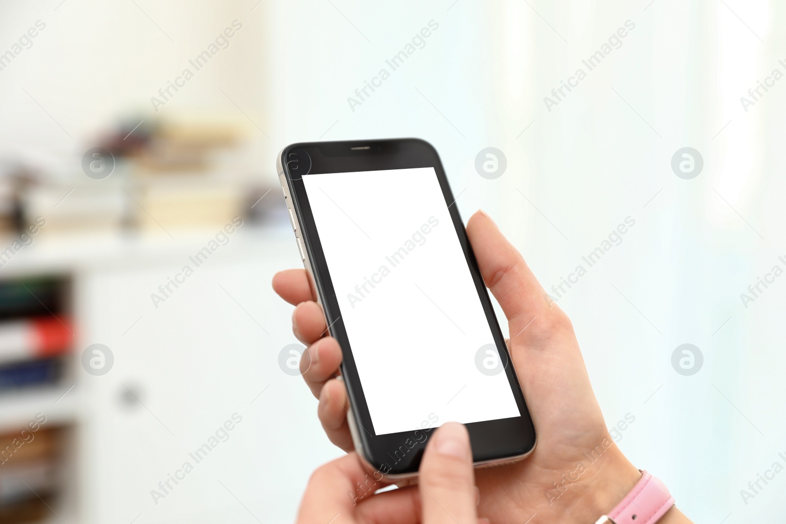 Photo of Woman holding smartphone with blank screen indoors, closeup of hands. Space for text