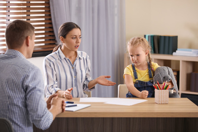 Photo of Child psychotherapist working with little girl and her mother in office