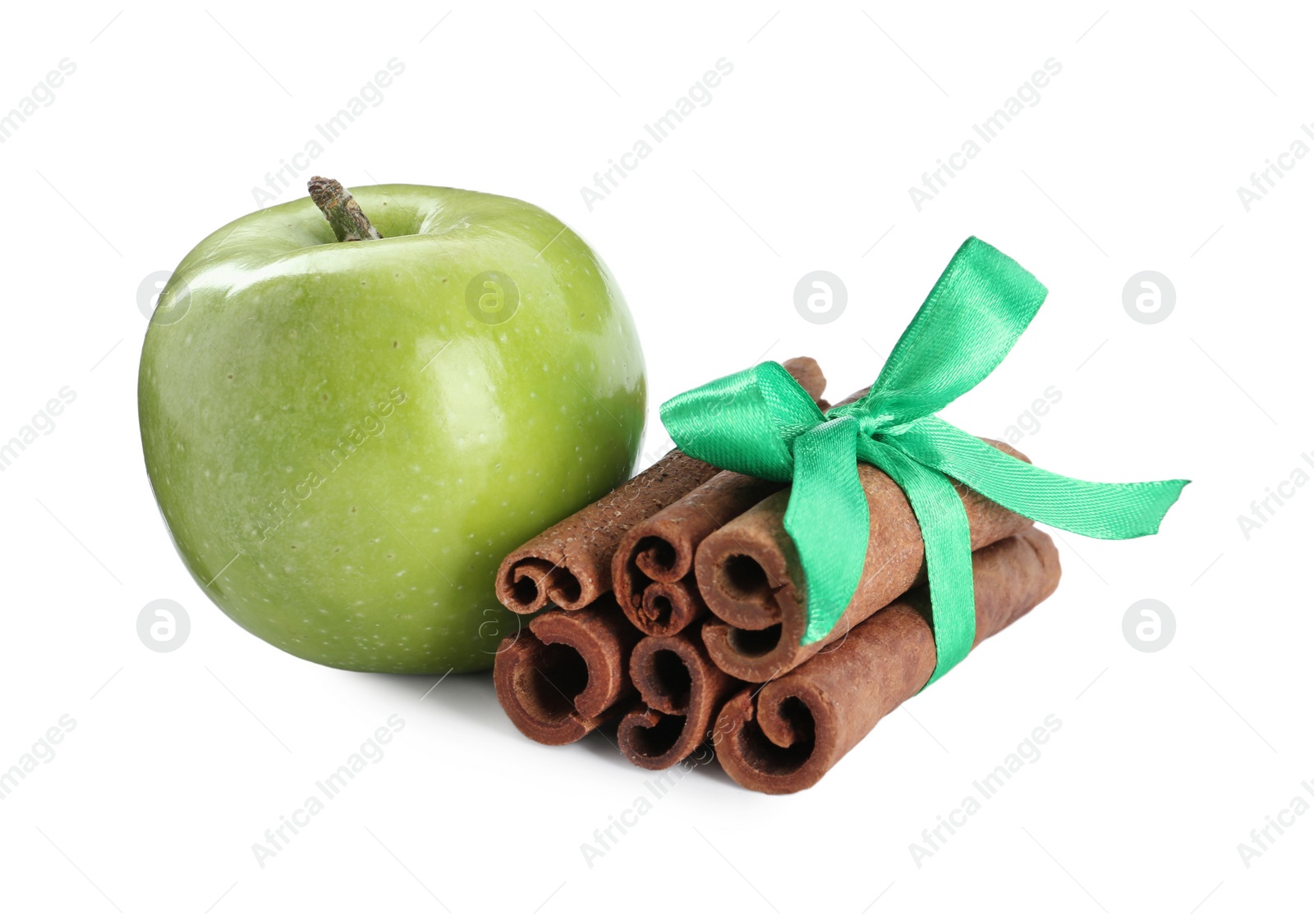 Photo of Cinnamon sticks and green apple on white background
