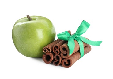 Photo of Cinnamon sticks and green apple on white background