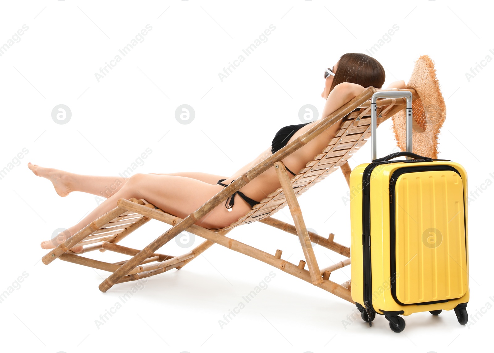 Photo of Young woman with suitcase on sun lounger against white background. Beach accessories