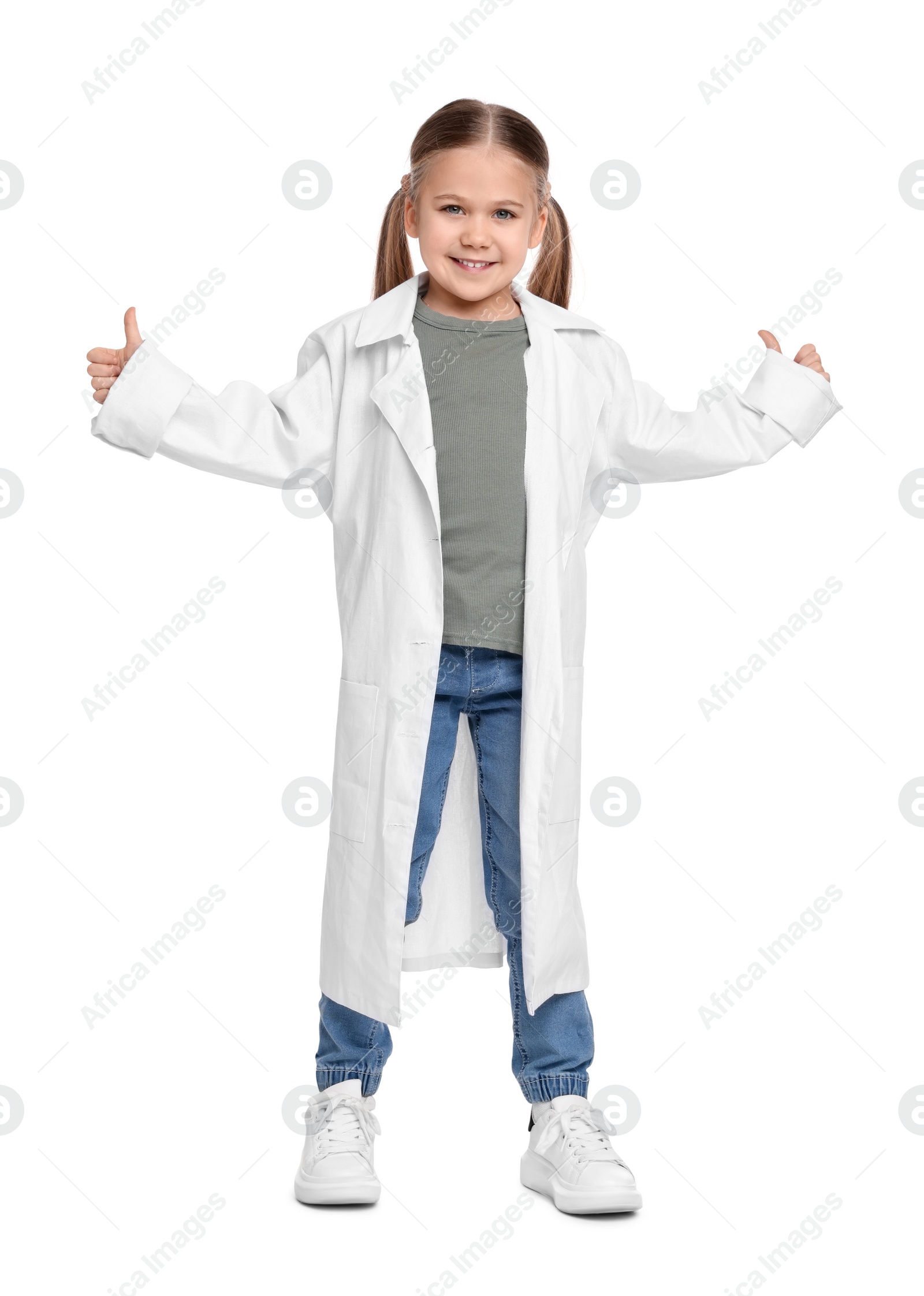 Photo of Little girl in medical uniform showing thumbs up on white background