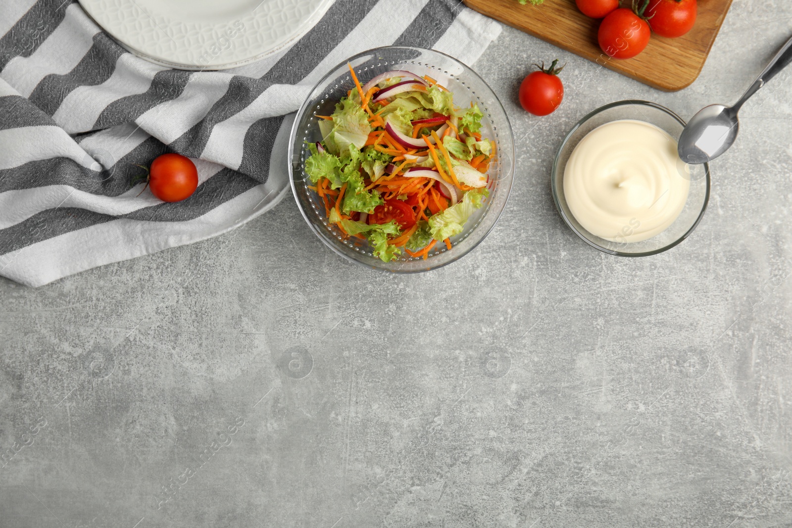 Photo of Delicious salad and bowl of mayonnaise on grey table, flat lay. Space for text