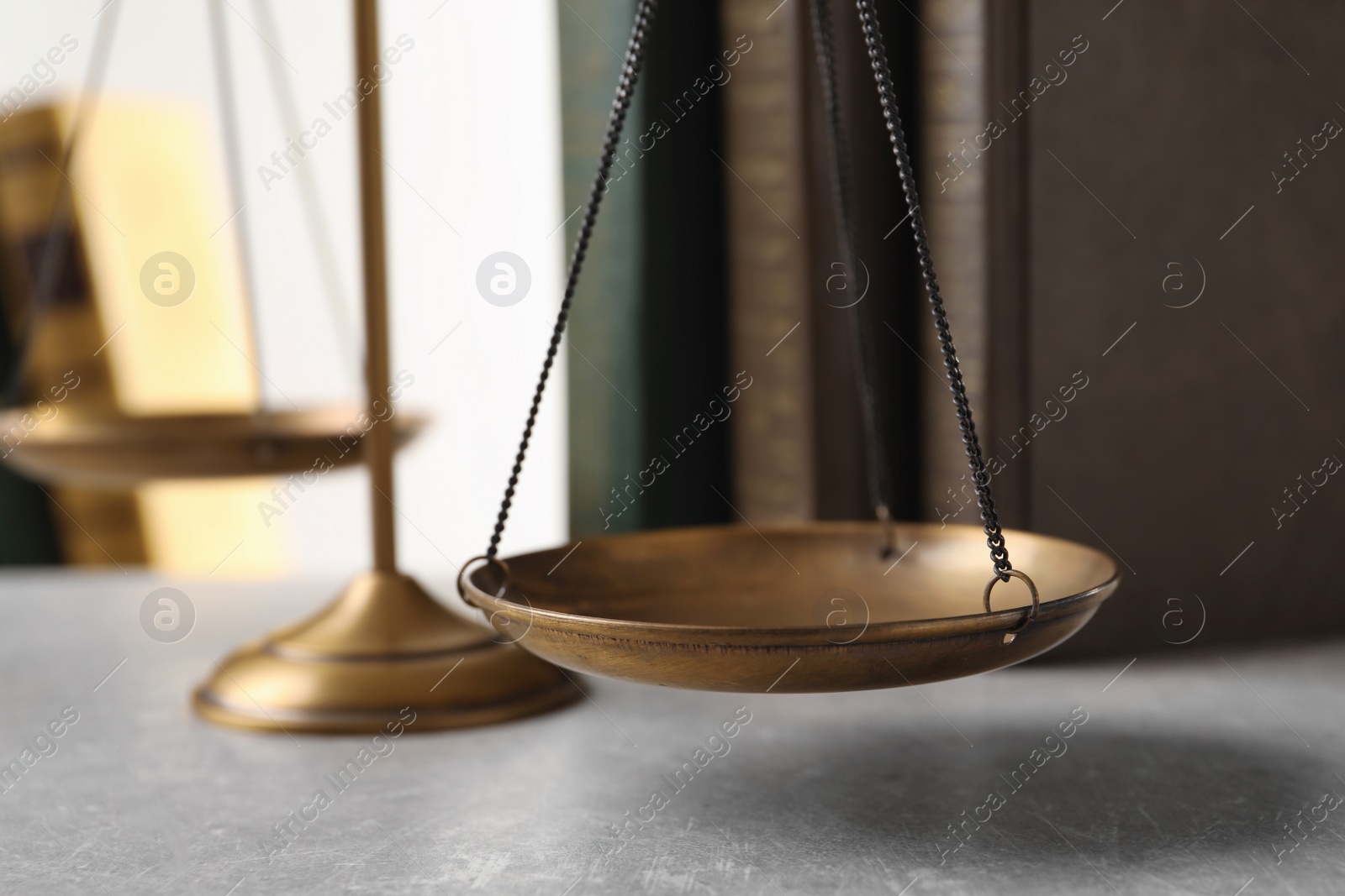 Photo of Scales of justice and books on table, closeup. Law concept