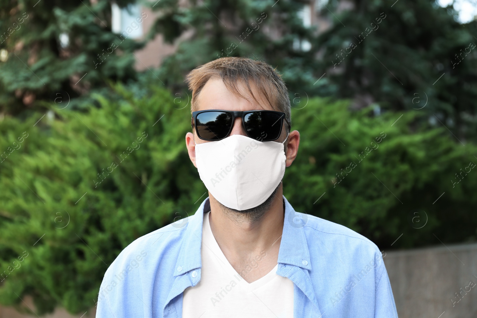 Photo of Man wearing handmade cloth mask outdoors. Personal protective equipment during COVID-19 pandemic