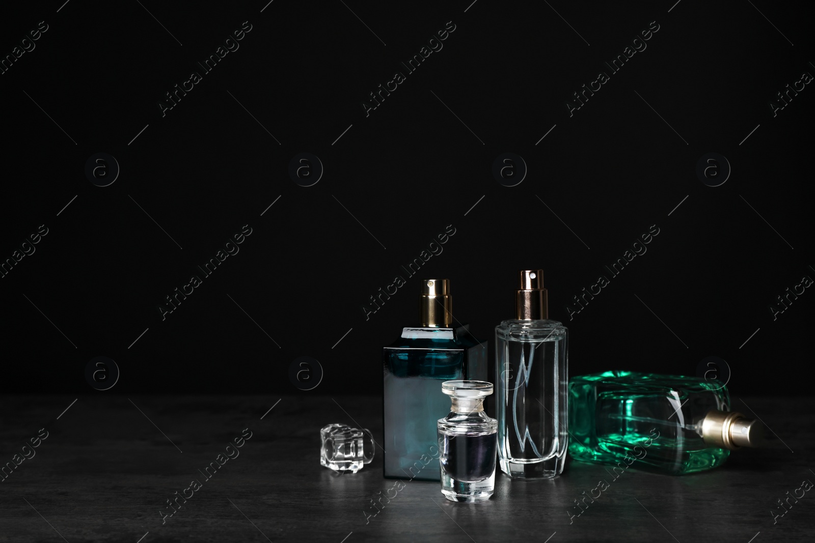 Photo of Perfume bottles on table against black background