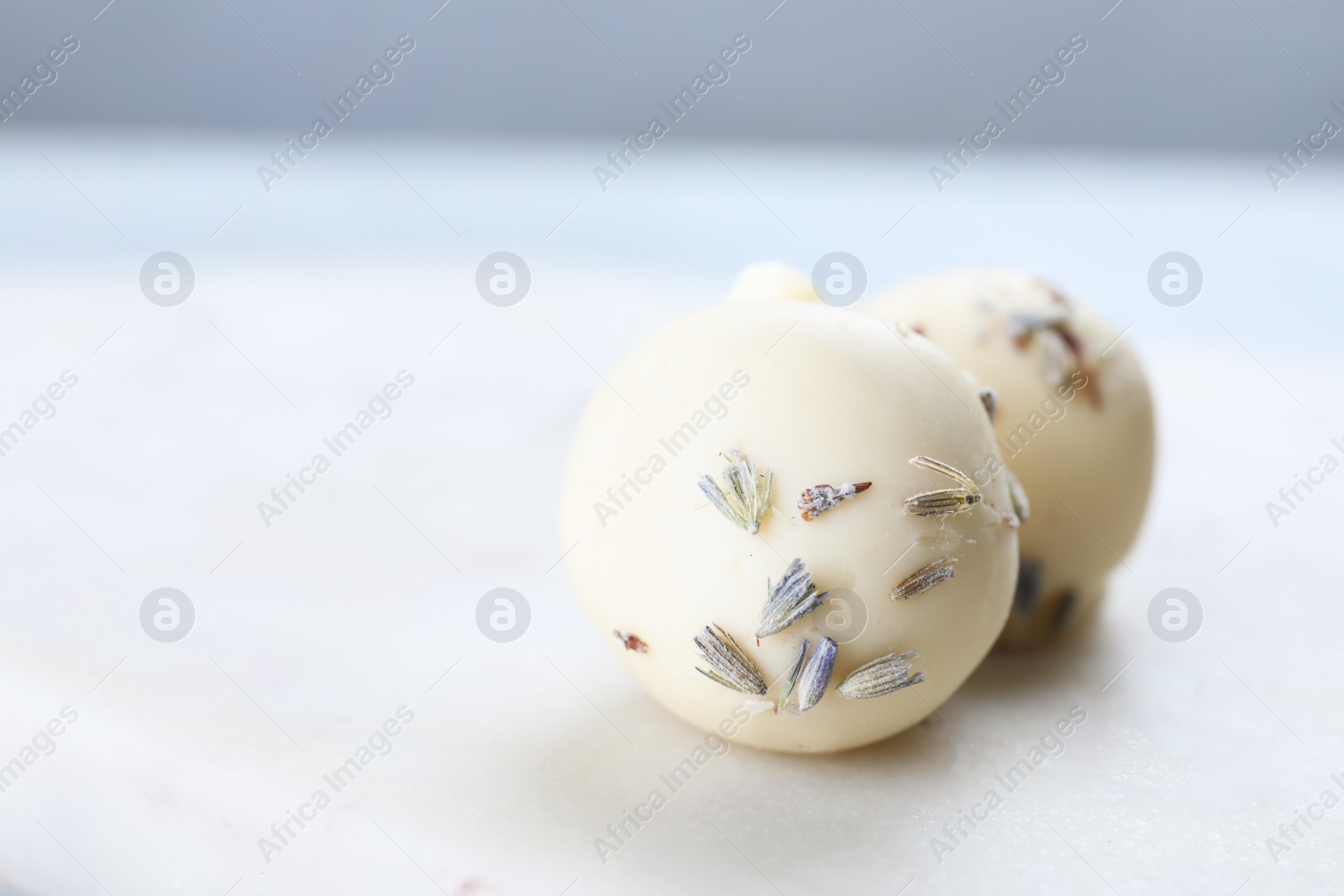 Photo of Delicious chocolate candies on white table, closeup. Space for text