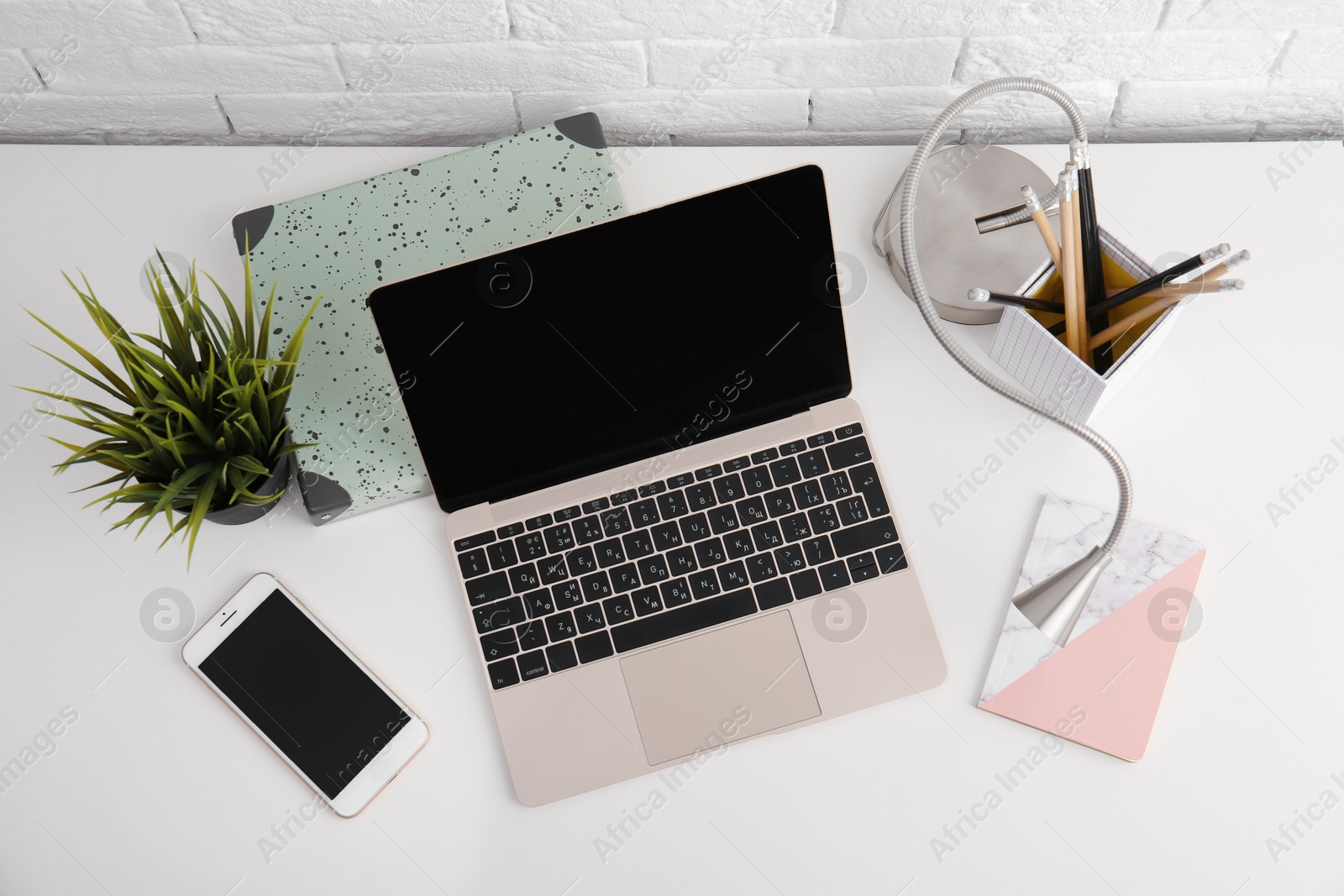 Photo of Modern workplace with laptop on table, above view. Mockup for design