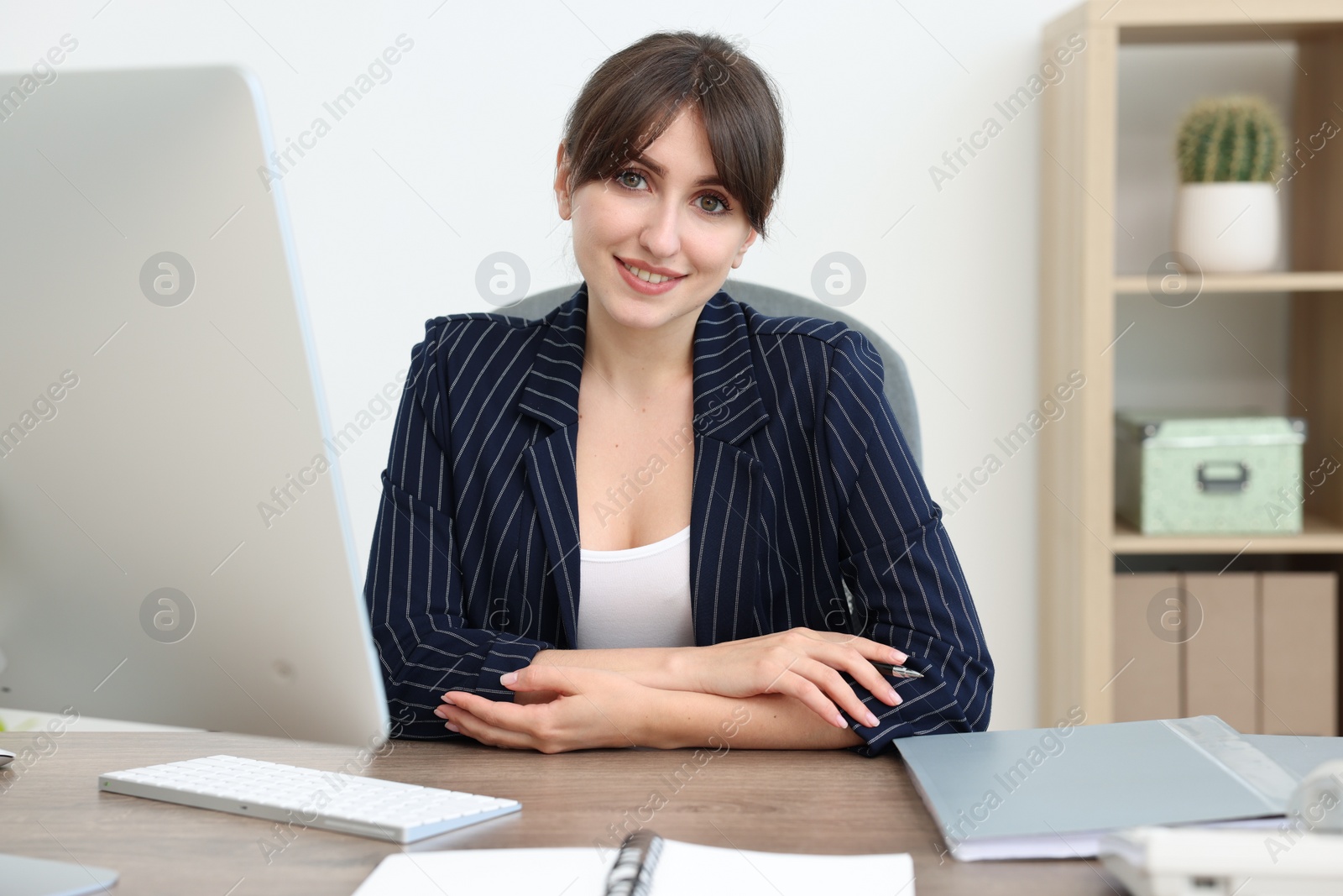 Photo of Portrait of smiling secretary at table in office