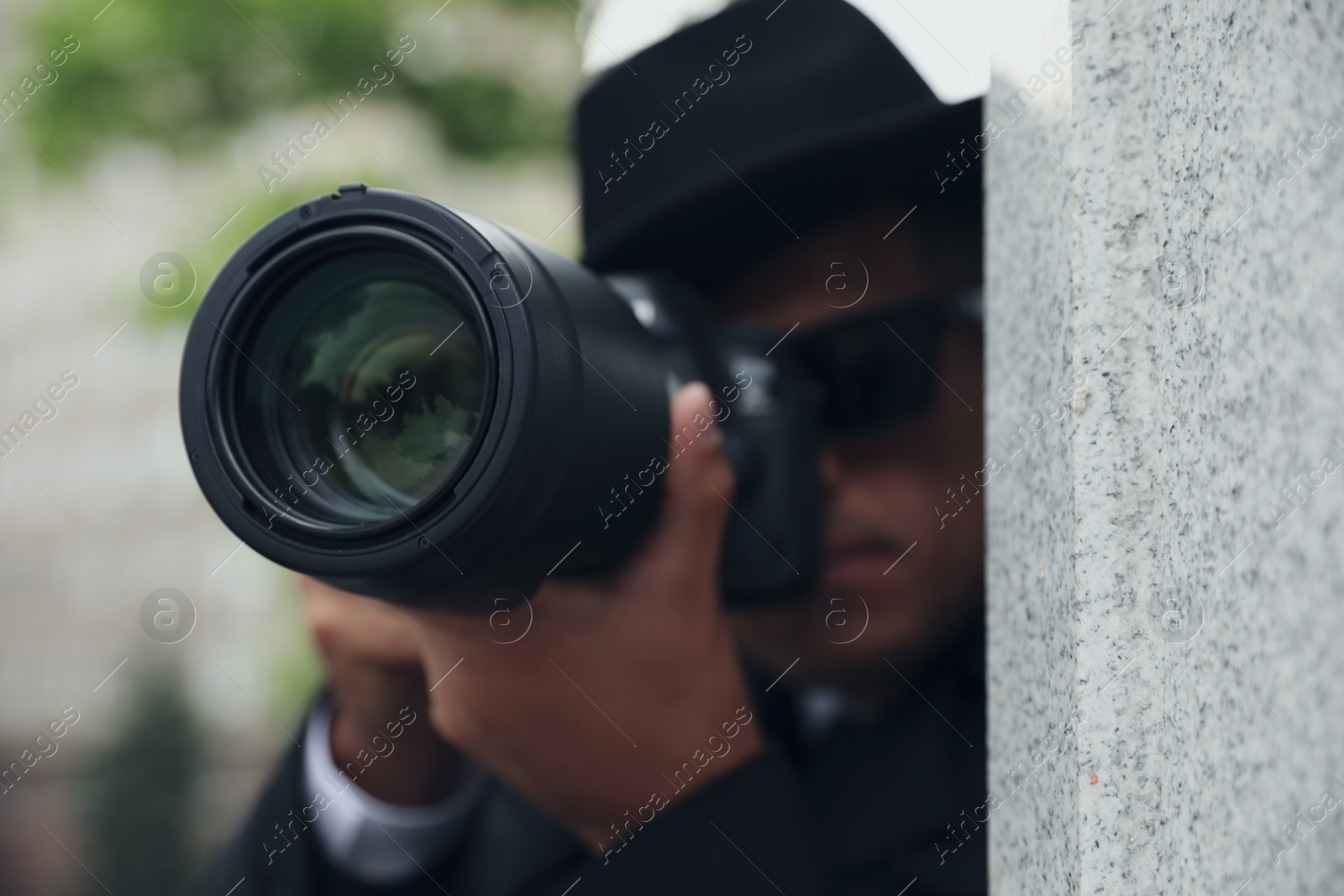 Photo of Private detective with modern camera spying outdoors, focus on lens