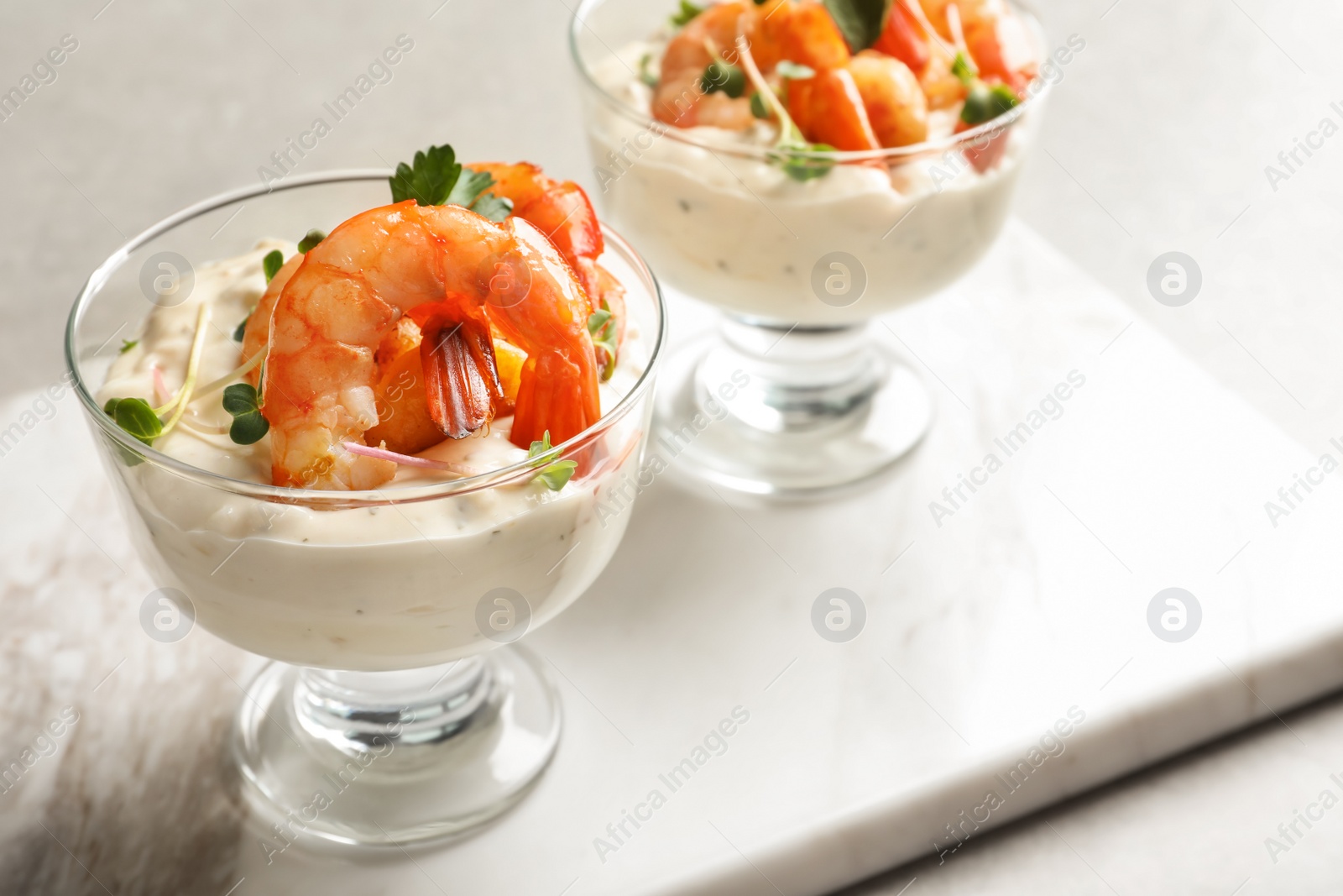 Photo of Bowls with fried shrimps and sauce on marble board