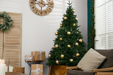 Photo of Beautiful decorated Christmas tree in living room interior