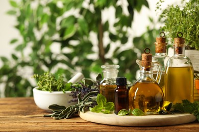 Different fresh herbs with oils on wooden table