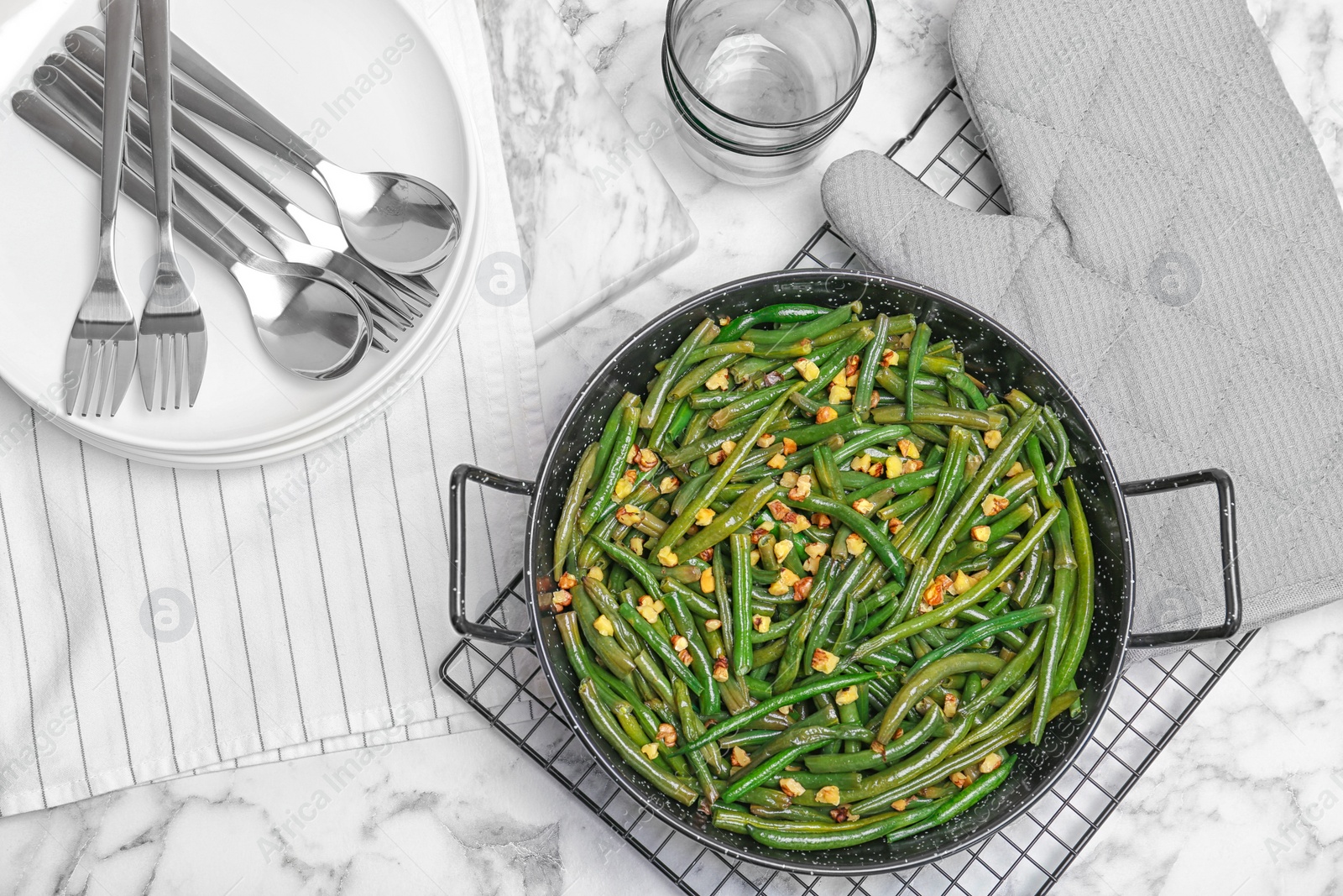 Photo of Yummy green beans with almonds in serving pan on table