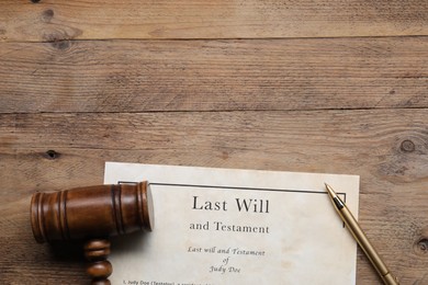 Photo of Last Will and Testament, gavel and pen on wooden table, top view. Space for text