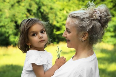 Photo of Happy mother with her cute daughter spending time together outdoors