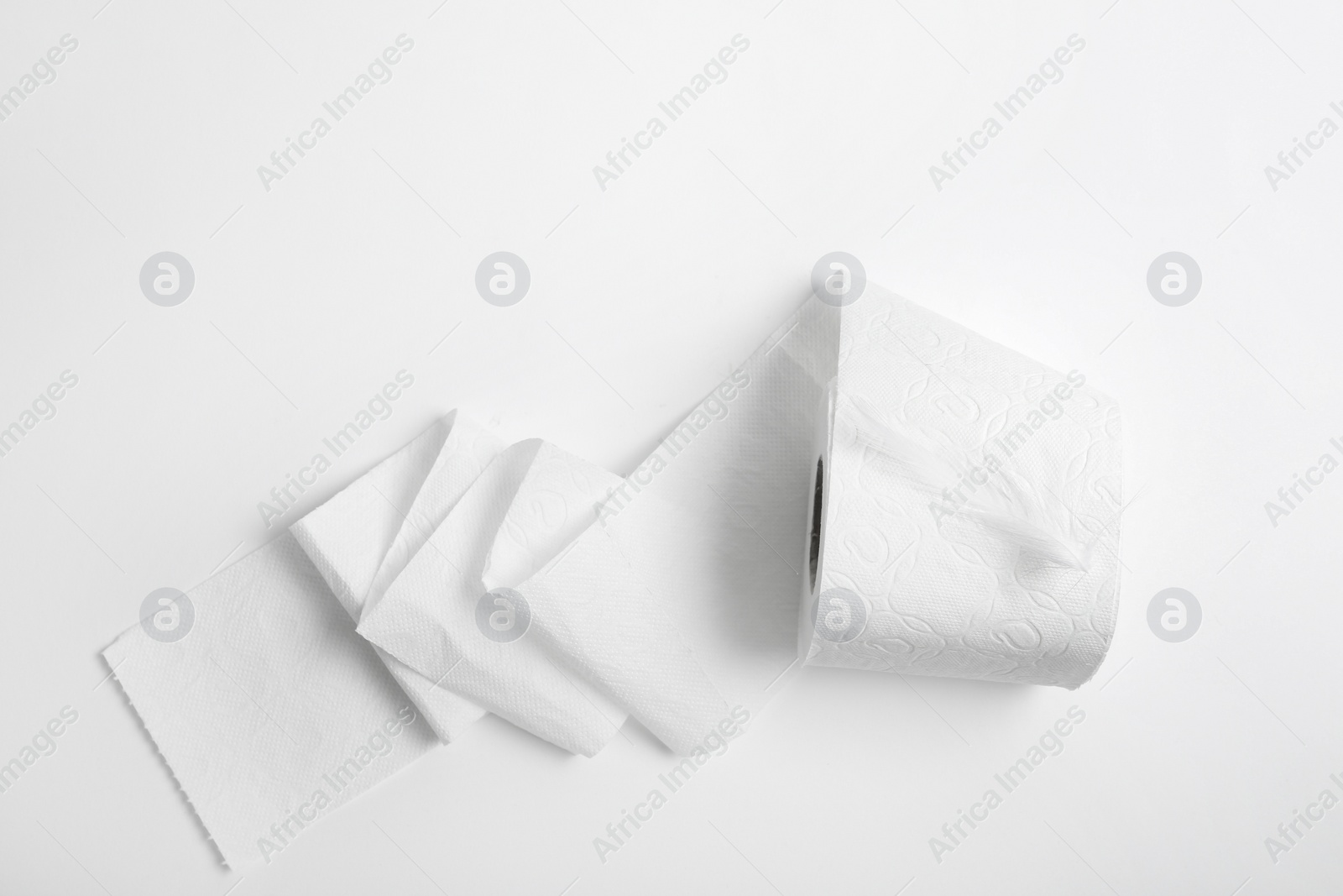 Photo of Roll of toilet paper with feather on white background, top view