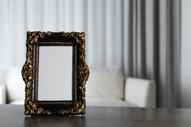 Beautiful vintage empty frame on wooden table, space for text