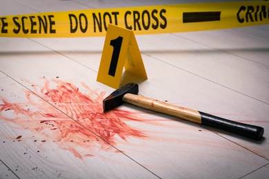 Hammer with blood and crime scene marker on white wooden background