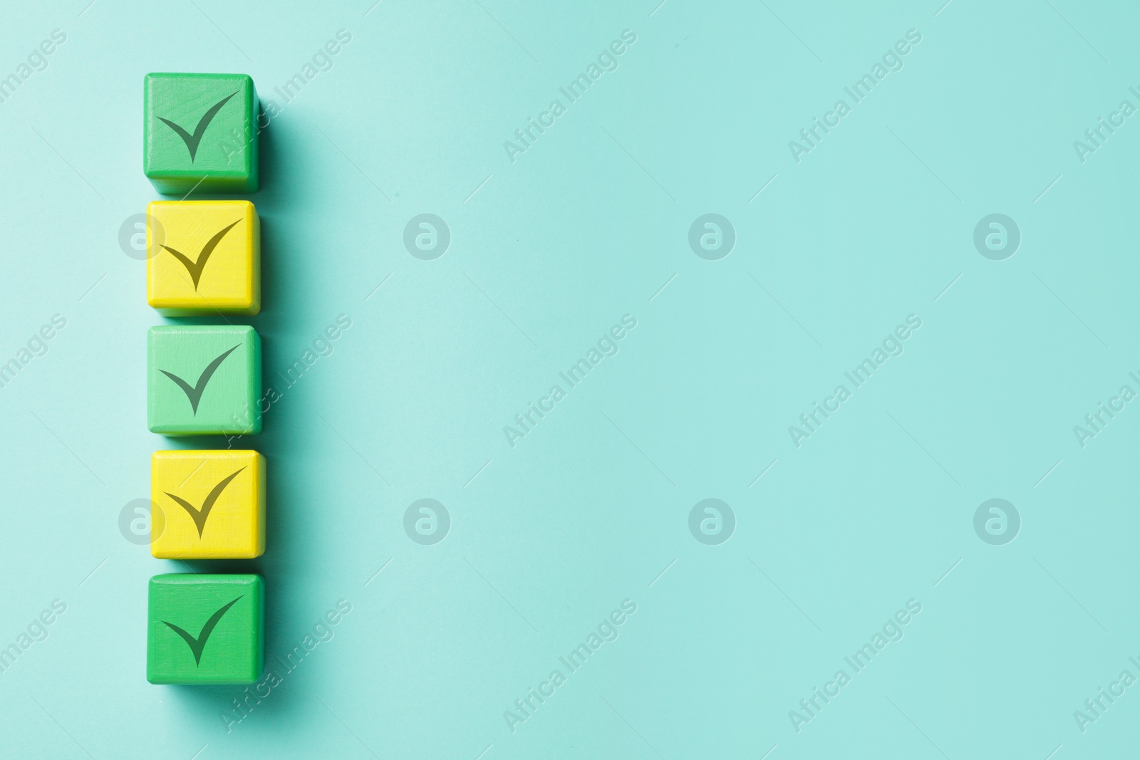 Image of Cubes with check marks on turquoise background, top view. Space for text