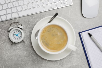 Photo of Cup of drink, alarm clock and stationery on light grey table, flat lay. Coffee Break