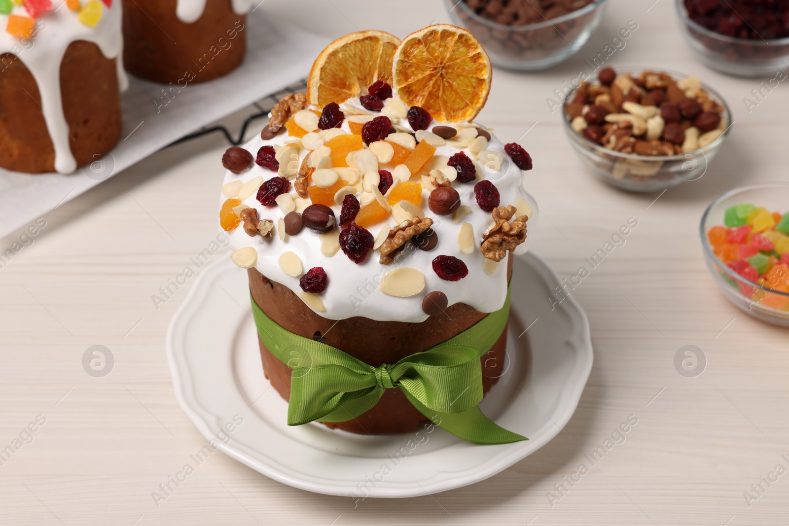 Photo of Tasty Easter cakes with dried fruits and nuts on white wooden table
