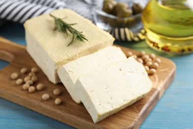 Photo of Cut tofu and soya beans on blue wooden table, closeup