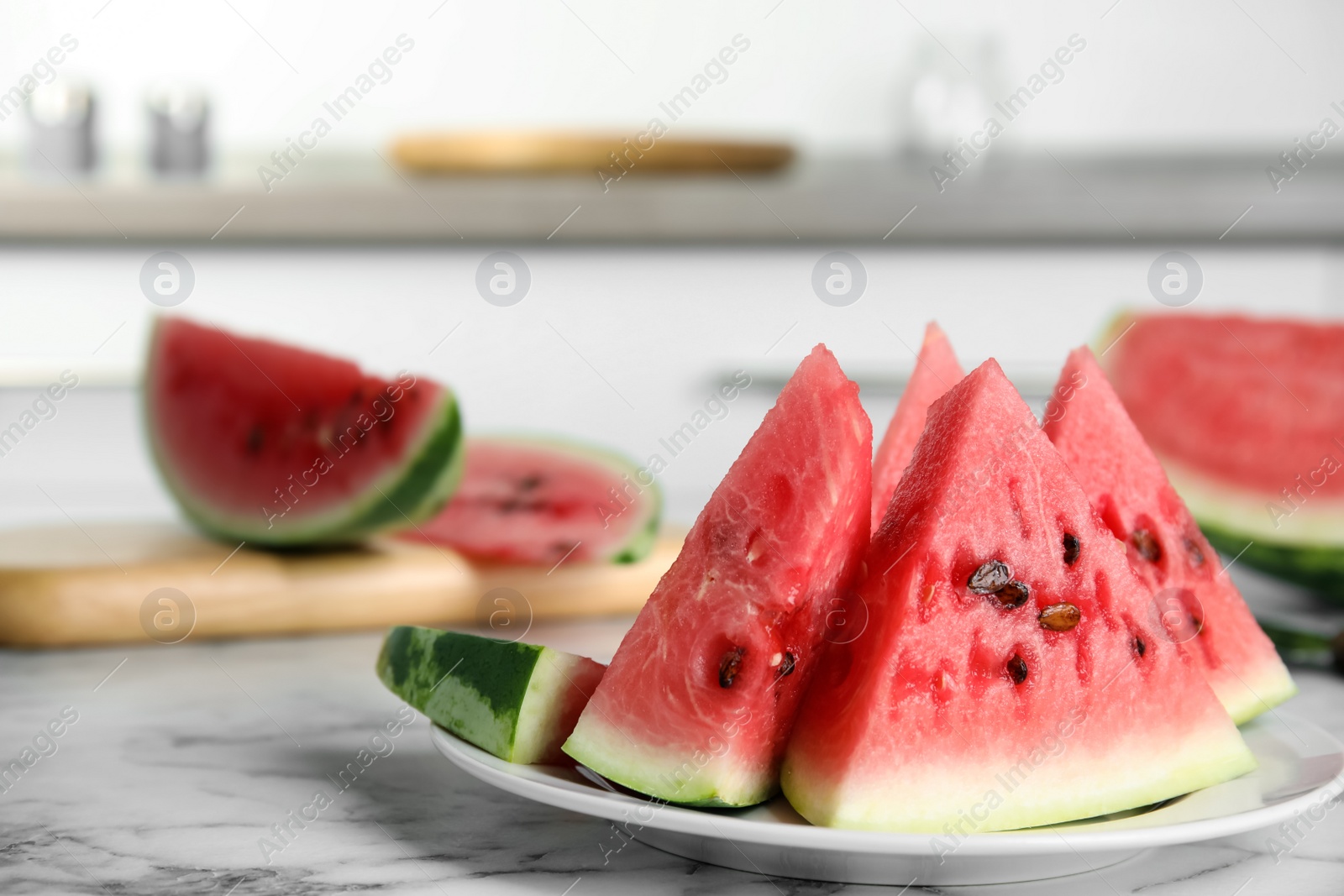 Photo of Yummy watermelon slices on white marble table in kitchen