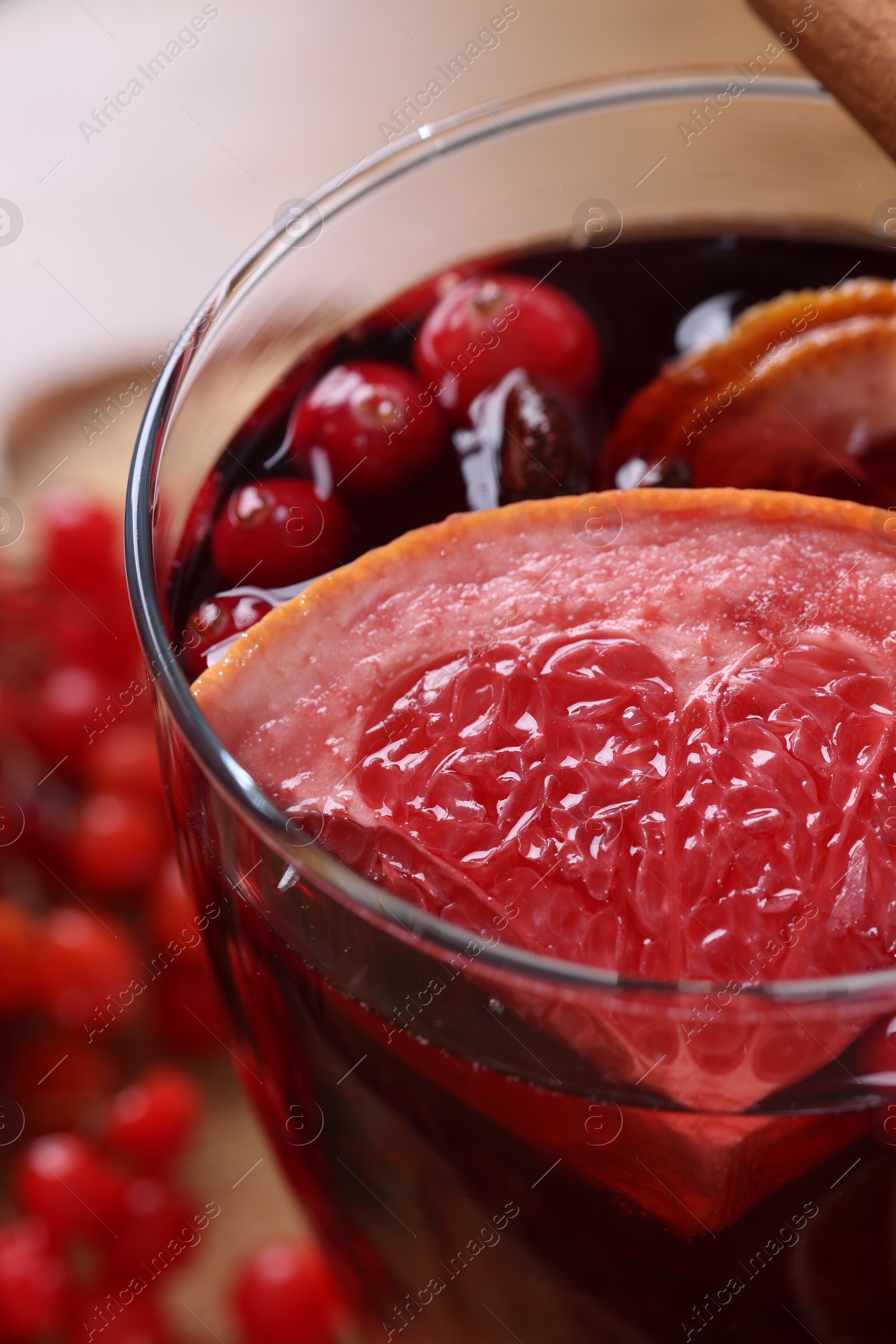 Photo of Aromatic mulled wine in glass on table, closeup