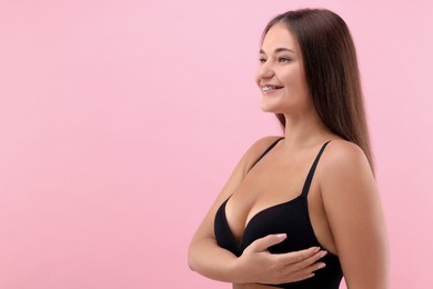Photo of Portrait of young woman with beautiful breast on pink background. Space for text