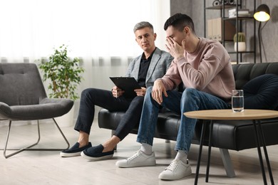 Photo of Professional psychotherapist working with patient in office