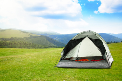 Image of Modern camping tent in mountains on sunny day