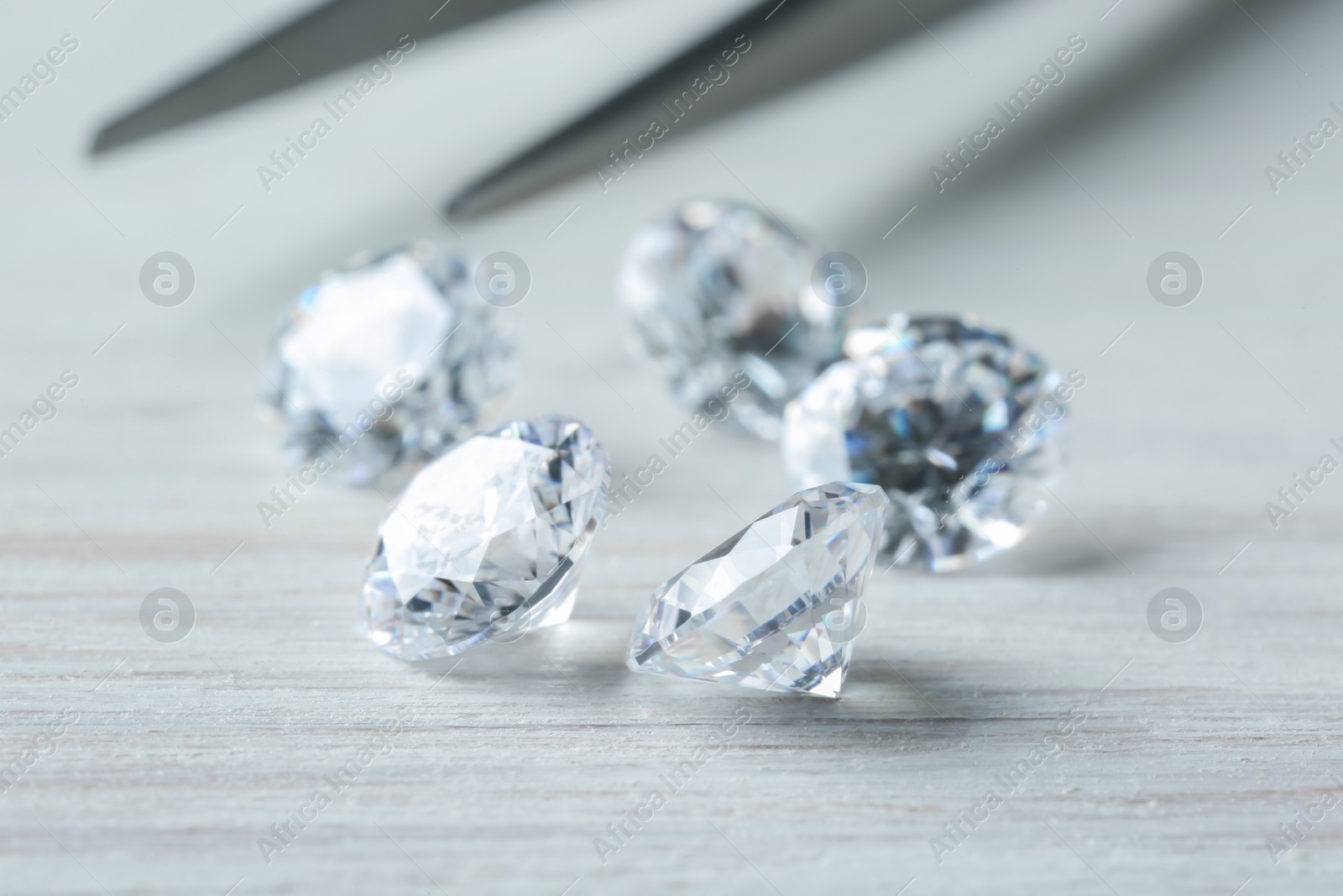 Photo of Beautiful shiny diamonds on light wooden table