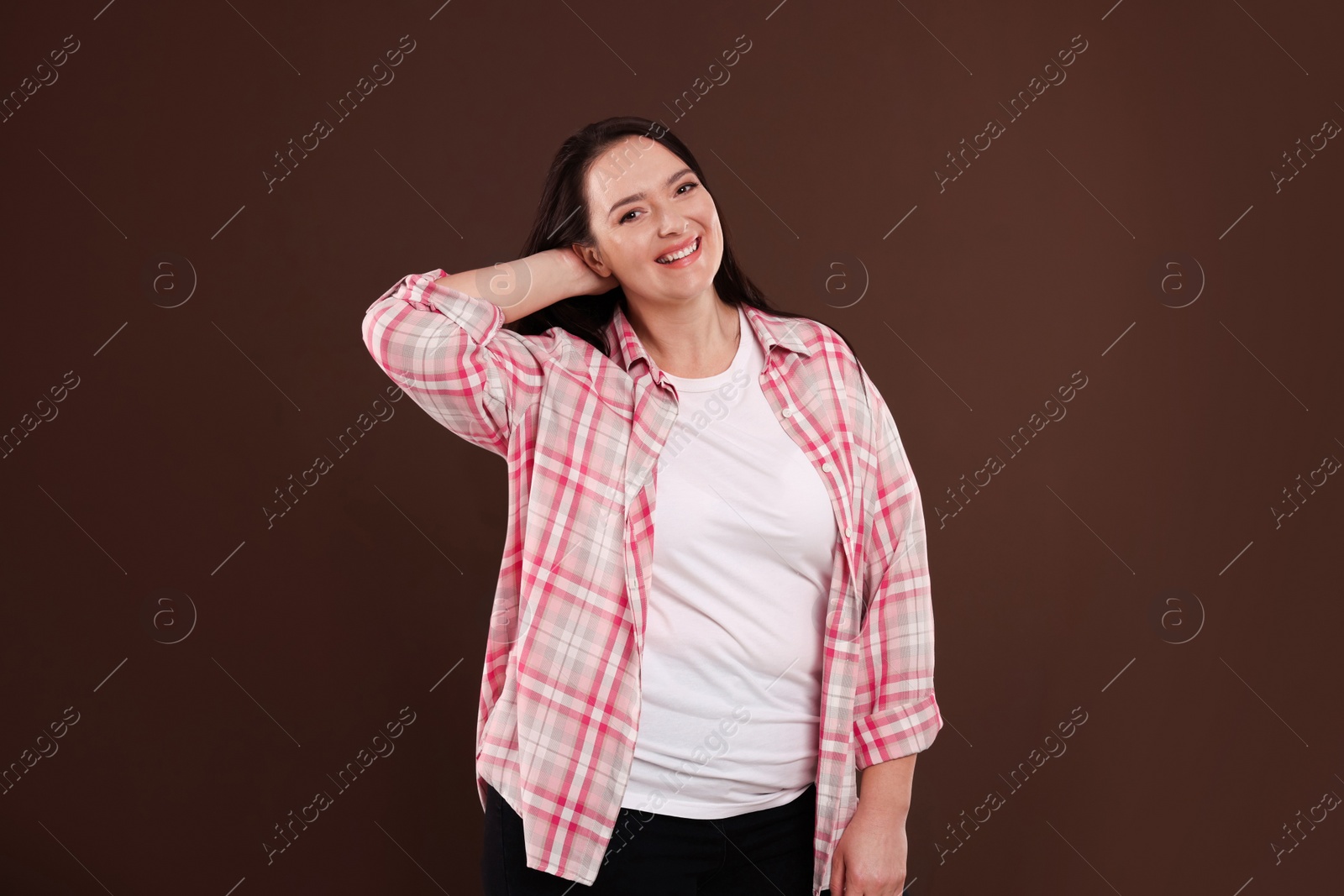 Photo of Beautiful overweight woman with charming smile on brown background