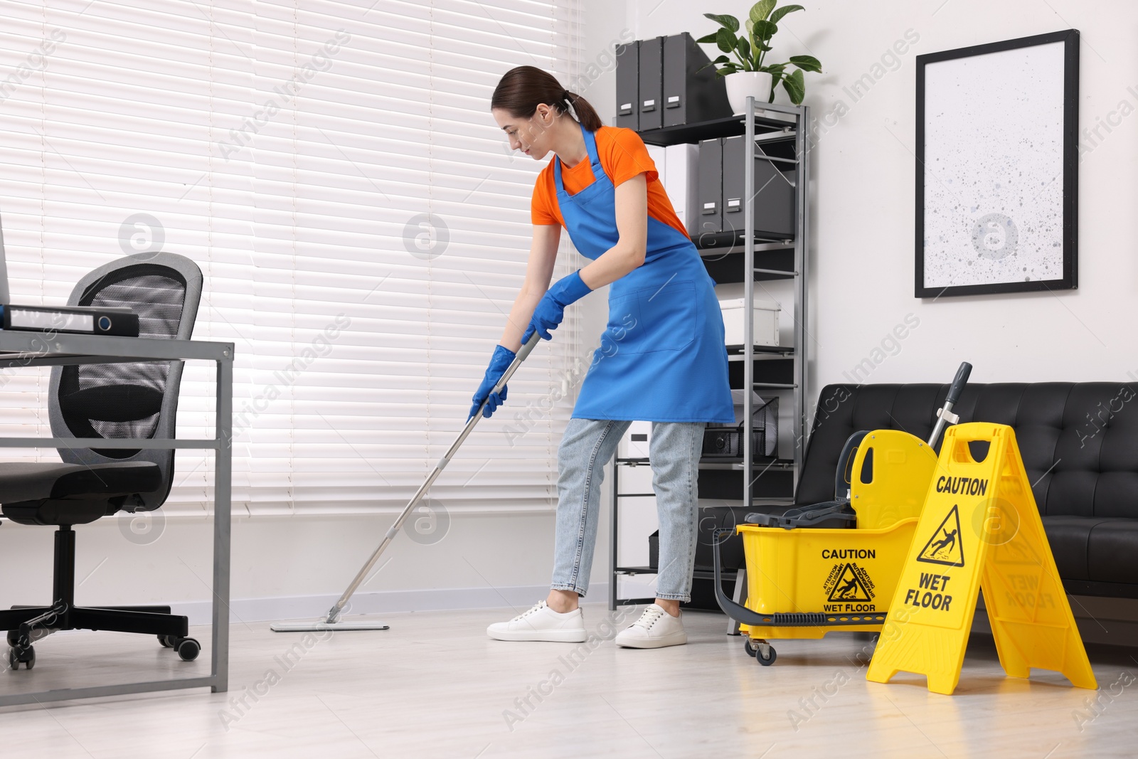 Photo of Cleaning service. Woman washing floor with mop in office