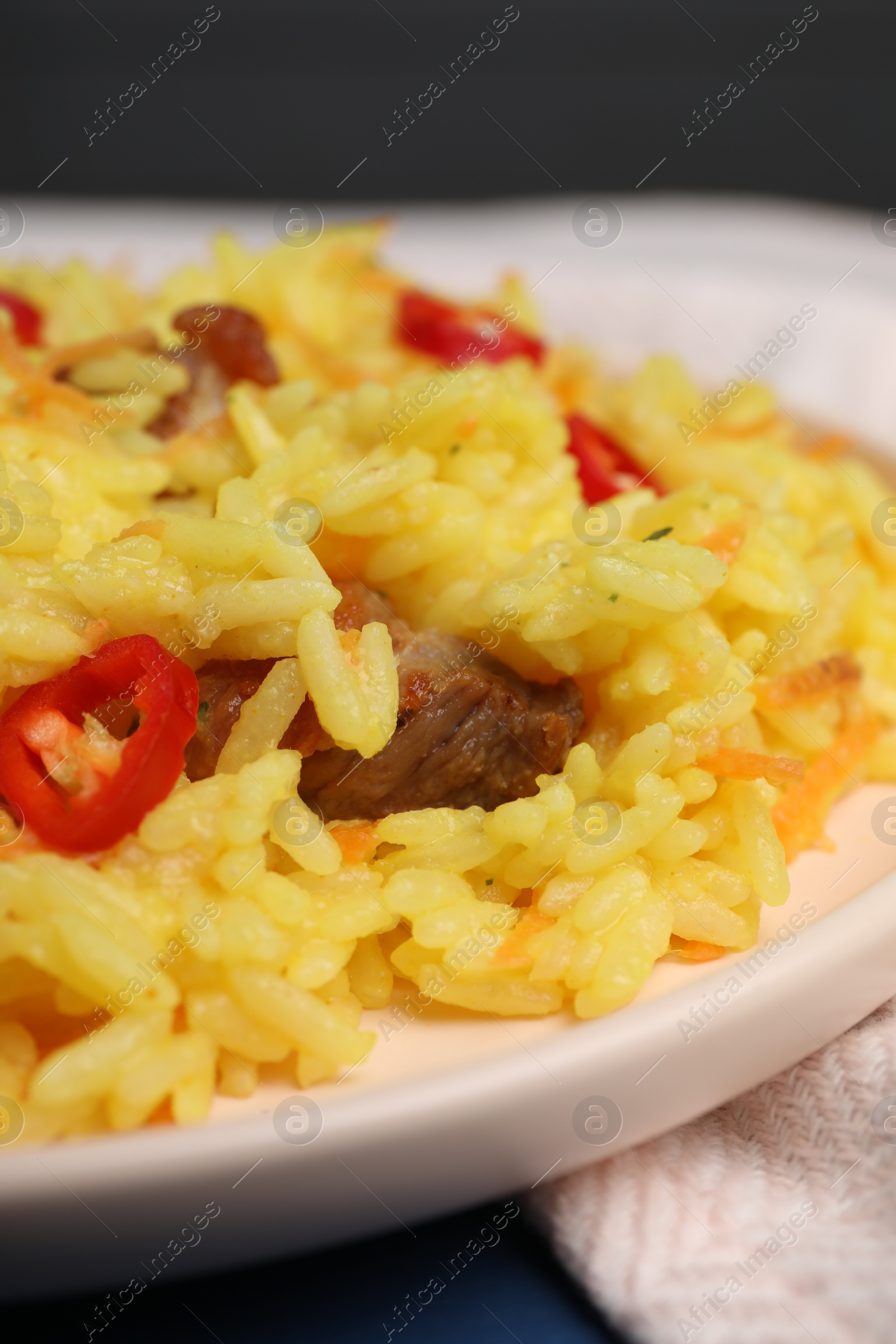 Photo of Delicious pilaf with meat on plate, closeup