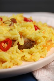 Delicious pilaf with meat on plate, closeup