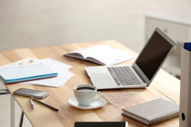 Photo of Modern laptop and supplies on table in office