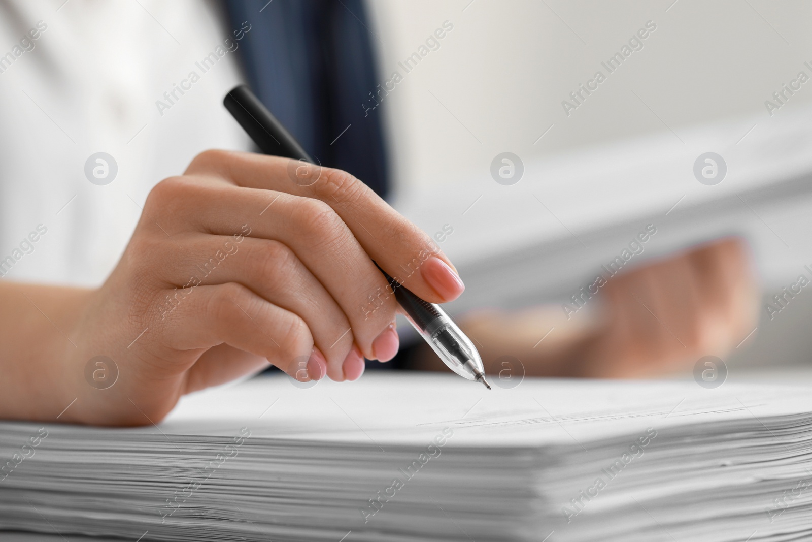 Photo of Woman signing documents at table in office, closeup. Space for text