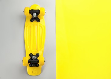 Photo of Yellow skateboard on color background, top view. Space for text