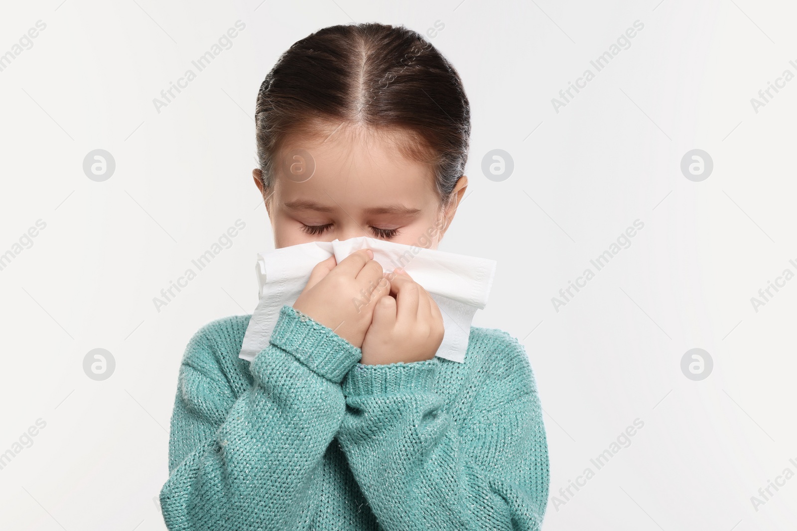 Photo of Girl blowing nose in tissue on white background. Cold symptoms