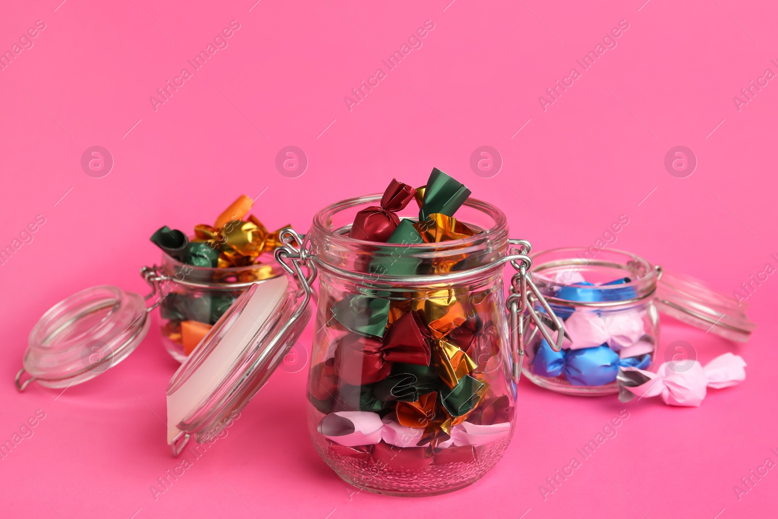 Photo of Candies in colorful wrappers on pink background