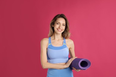 Photo of Beautiful woman with yoga mat on pink background