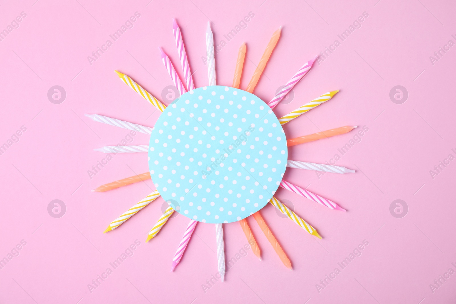 Photo of Colorful birthday candles and card on pink background, top view with space for text