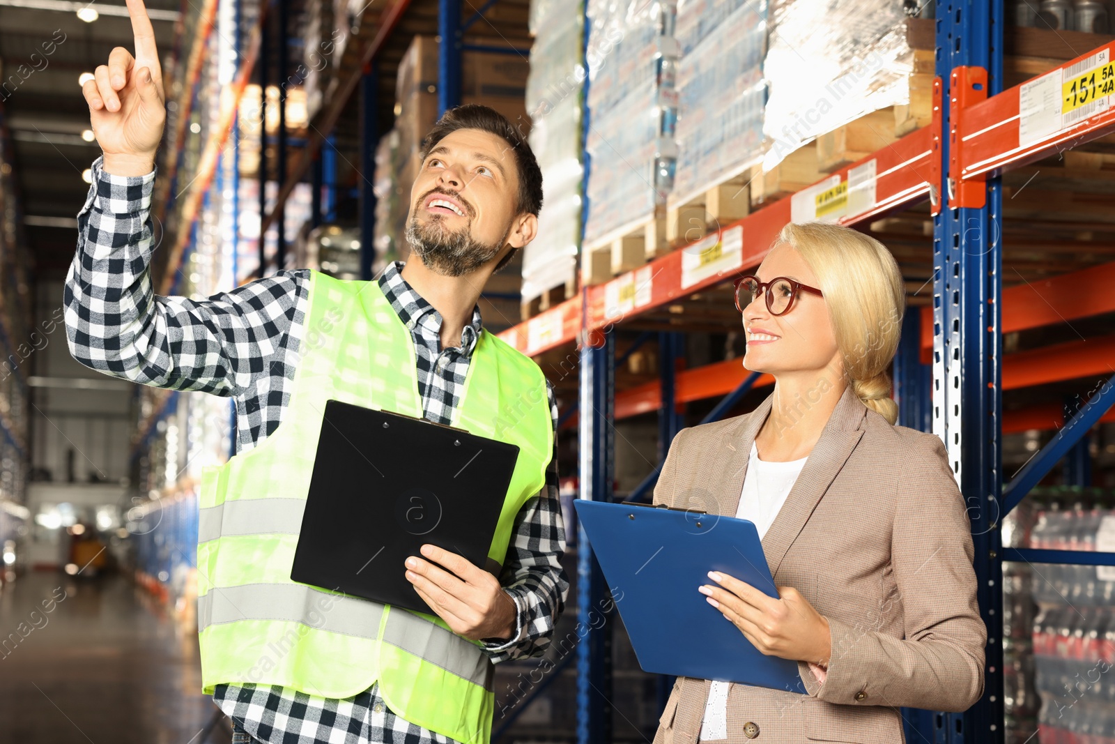 Photo of Manager and worker in warehouse with lots of products